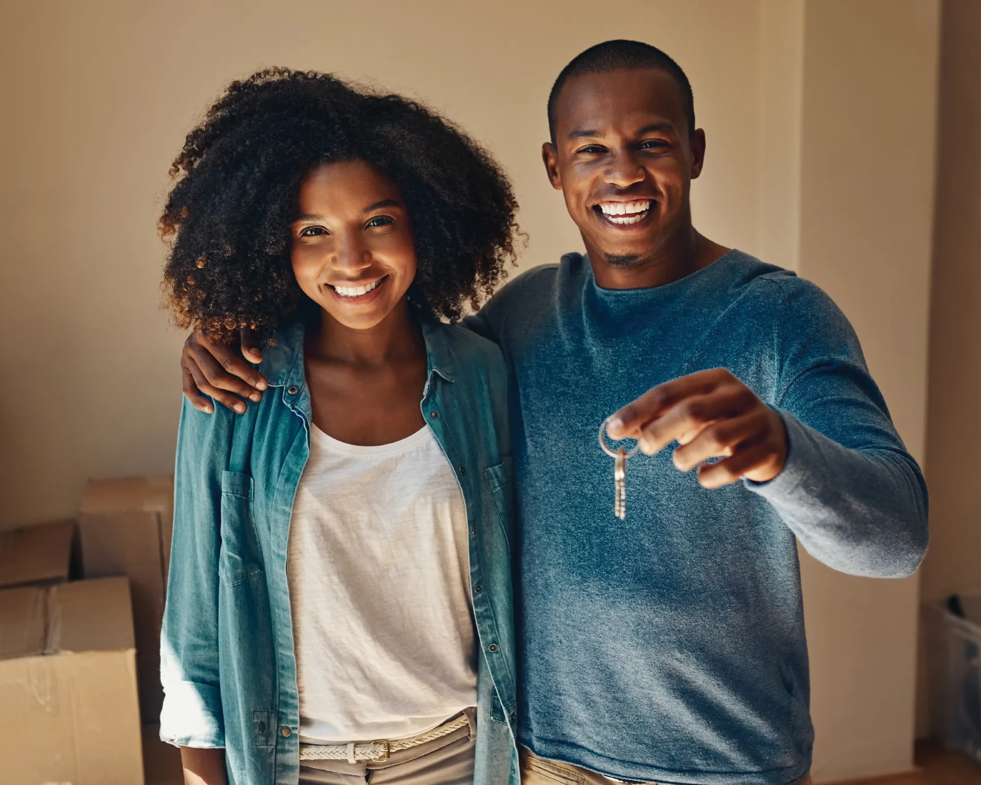 Young couple happy holding new house keys.